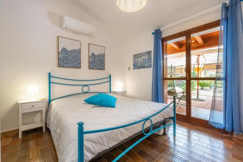 a bedroom with a bed with blue pillows on it at Villetta Pineta in Santa Margherita di Pula