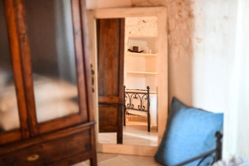 a room with a door and a mirror and a chair at Trulli Laetitia in Martina Franca