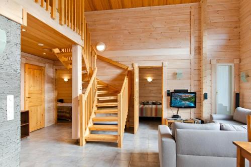 a log cabin with a staircase and a living room at Kolin Lotus Superior-Amero Cottages in Kolinkylä