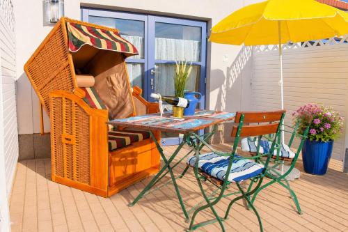 a table and a chair and an umbrella on a patio at Haus Meeresrauschen in Rerik
