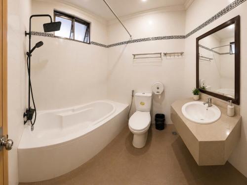 a bathroom with a tub and a toilet and a sink at Khách Sạn Mỹ Kim in Cà Mau