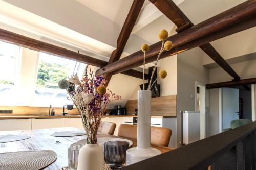 eine Küche und ein Esszimmer mit einem Tisch mit Blumen in der Unterkunft Emmis Appartements in Bremm
