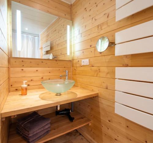 a bathroom with a sink in a wooden wall at Chalet des Épicéas in Chorges