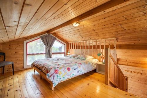 a bedroom with a bed in a wooden room at Chalet des Épicéas in Chorges