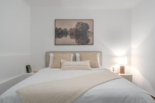 a white bedroom with a large white bed with a white blanket at Riviera by Urban Luxy in Athens