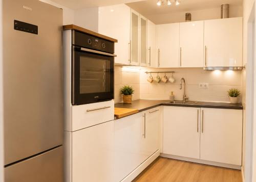 a kitchen with white cabinets and a refrigerator at Athena in Koper