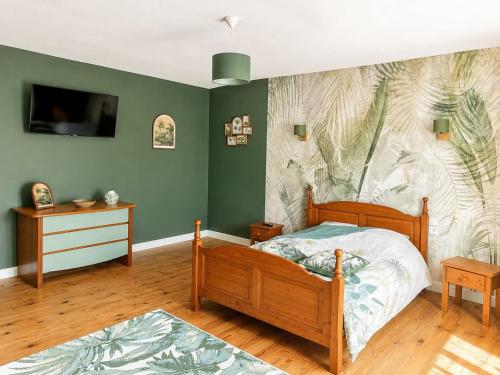 a bedroom with a bed and a wall with a mural at chambres nature in La Celle-sous-Gouzon