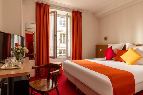 a hotel room with a bed and a table and a desk at Hôtel Saint Roch in Paris