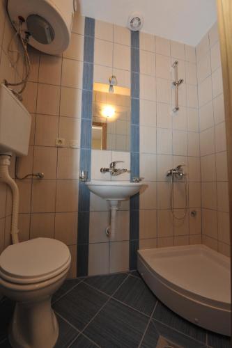 a bathroom with a toilet and a sink and a tub at Villa Marija in Struga