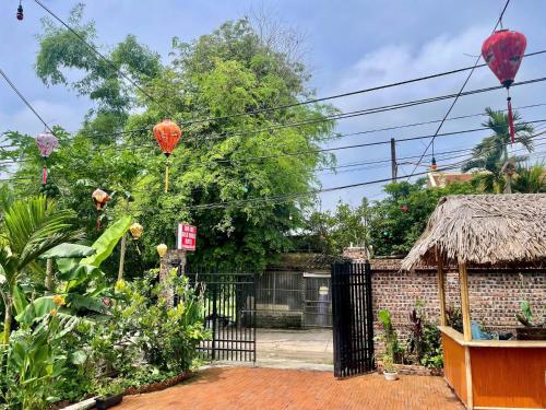 a garden with a gate and a building with a roof at Tam coc Sylvani Homestay in Vũ Lâm