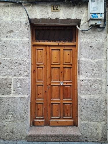 a wooden door in a stone building with the number at Casa El Papamoscas in Burgos