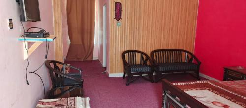 a room with two chairs and a room with red walls at Stone Man's Hotel Samana Heights in Battakundi
