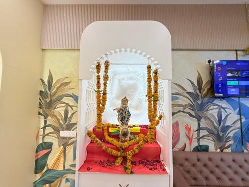 a altar in a room with a statue at Shri Gopal Durga Dham Hotel And Restaurant in Ujjain