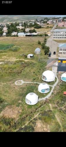 a group of white tents in a field at Lakeside glamping in Tsovagyugh