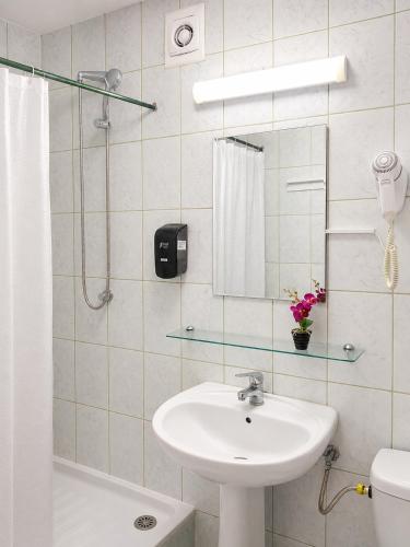 a bathroom with a sink and a shower with a mirror at Hotel Venus in Venus