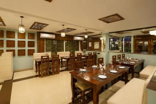 a dining room with wooden tables and chairs at Hotel Luxury Stay Igi Airport Delhi in New Delhi