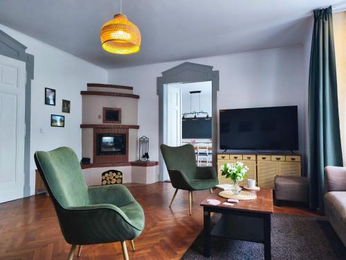 a living room with two green chairs and a couch at Vila Rychleby Javorník in Javorník