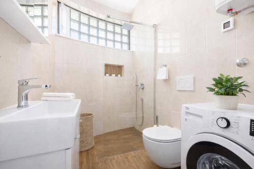 a white bathroom with a toilet and a sink at Pula Paradise in Pula