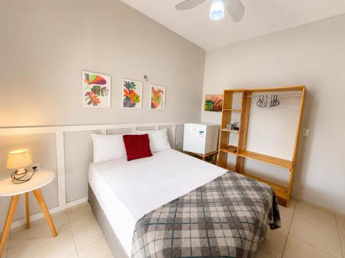 a bedroom with a white bed and a small table at Hosts BR - La Serena Suíte Cumbuco in Caucaia