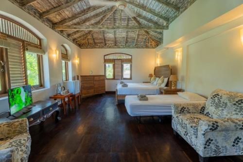 a bedroom with two beds and a tv in a room at Amara Villa in Galle