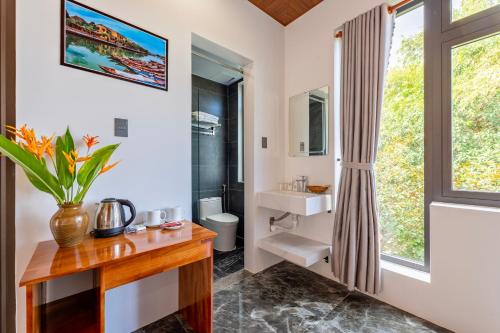 a bathroom with a sink and a toilet and a window at Laughter Garden villas in Tân Thành (1)
