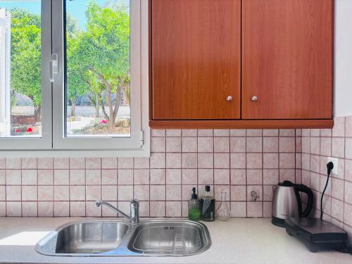 a kitchen counter with a sink and a window at Casa Crystallia in Chalkida