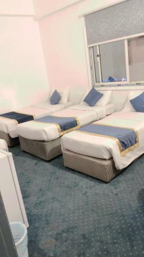 a group of four beds in a room at Nour Taba Apartments in Medina