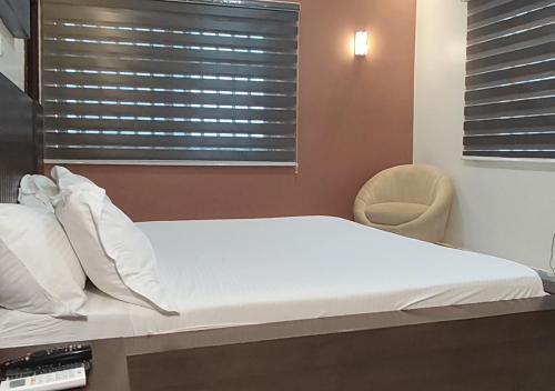 a bed in a room with a window and a chair at Appartement Une Chambre Salon Ouando - SKYFORCE in Porto-Novo