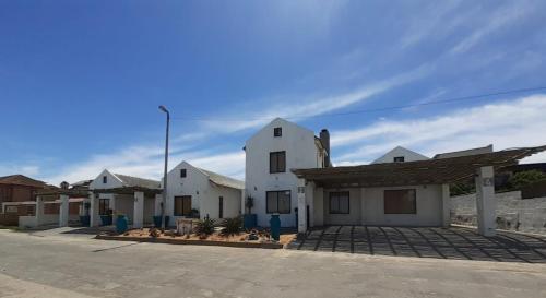 a row of white buildings in a parking lot at Sunset Lagoon in Port Nolloth