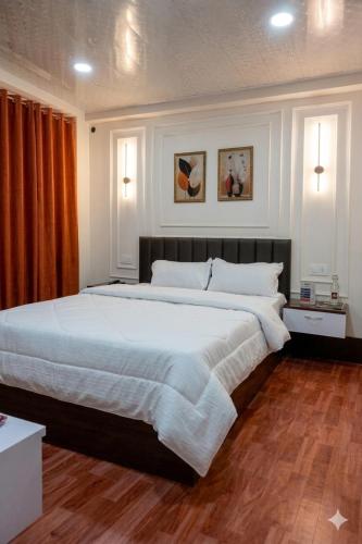 a large bedroom with a large bed with white sheets at Kadamba Bnb Homestay in Kurseong