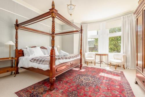 a bedroom with a canopy bed and a red rug at Hazelton Townhouse - Crail in Crail