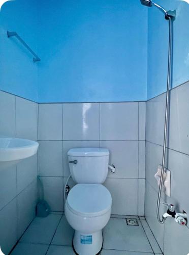 a bathroom with a white toilet and a sink at Bulan Guesthouse in San Isidro