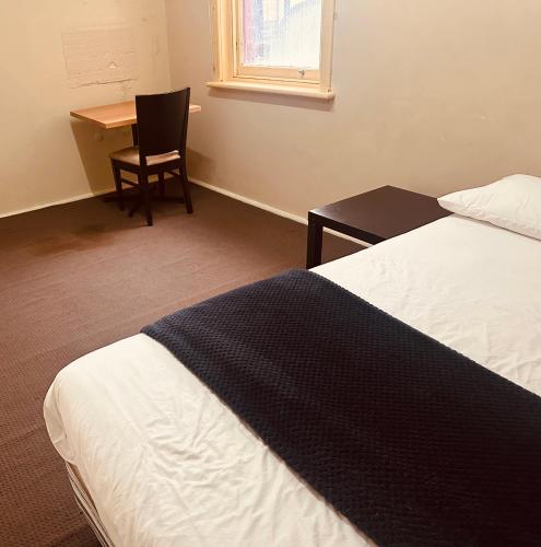 a bedroom with a bed and a desk and a chair at Ararat Hotel in Ararat