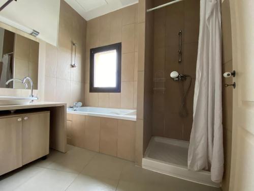 a bathroom with a shower and a tub and a sink at Résidence Lagrange Vacances L'Oustau de Sorgue in L'Isle-sur-la-Sorgue