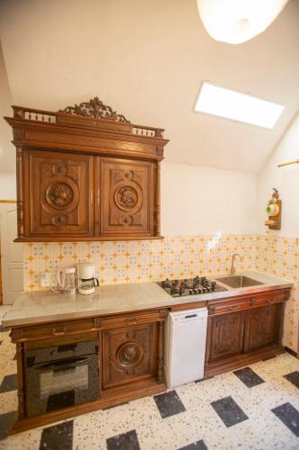 a kitchen with wooden cabinets and a sink at chez nous - la une in Marseillan