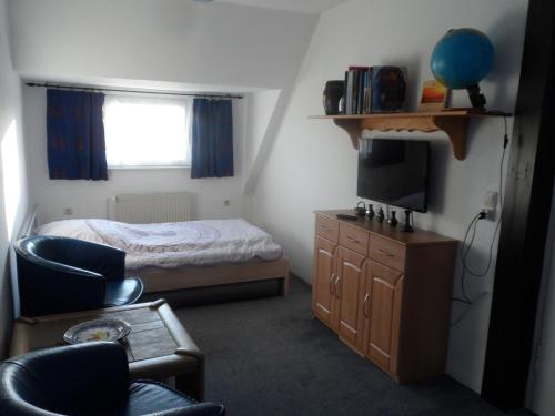 a small bedroom with a bed and a television at Ostseenähe Homestay in Gadebusch