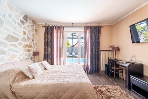 a bedroom with a bed and a desk and a window at Villa Béatrice - Piscine in Hochfelden