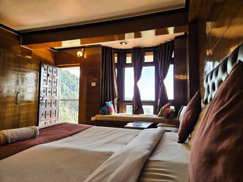 a bedroom with a large bed with a window at Hotel Monal Inn, Pangot Wildlife and Bird Sanctuary in Nainital