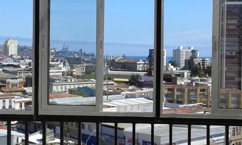 a view of a city from a window at Hostal Tunquelen in Valparaíso
