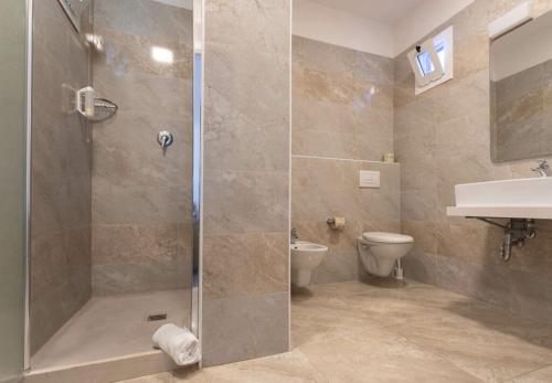 a bathroom with a shower and a toilet and a sink at Miramare Resort in Rimini