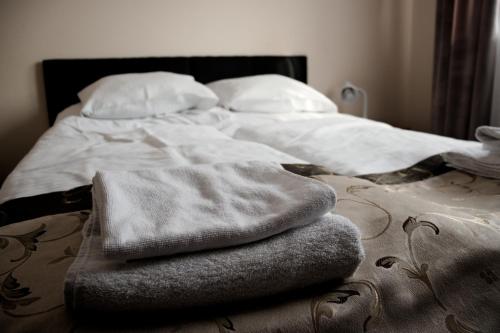 a bed with two towels sitting on top of it at Pensjonat Korona in Modrzyca