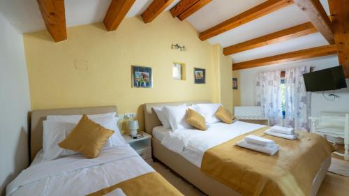 a bedroom with two beds in a room with wooden ceilings at Villa Katarina by Villas Guide in Barban