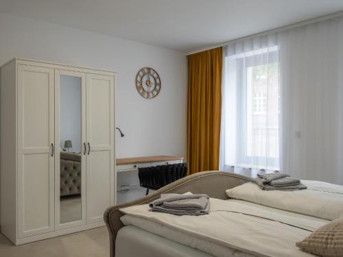 a bedroom with two beds and a clock on the wall at Ferienwelt Wittenberge in Wittenberge