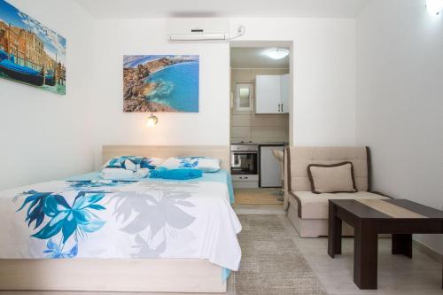 a bedroom with a bed and a table and a couch at Mejić Apartments in Kotor