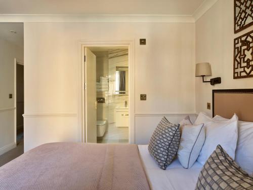 a bedroom with a bed with white sheets and pillows at Collingham Serviced Apartments in London