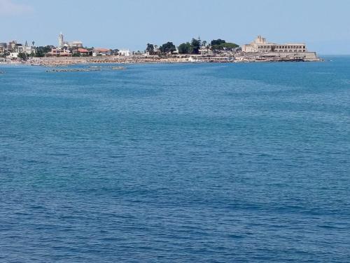 a large body of water with a city in the background at Riflessi nosTrani - Seaside Rooms in Trani