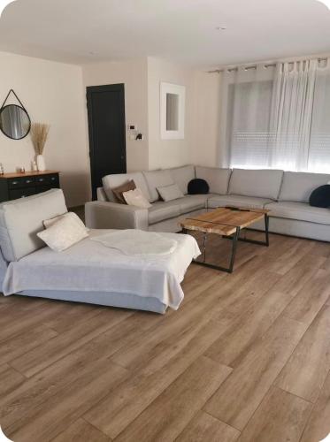a living room with a couch and a table at Belle villa à la mer in Sérignan