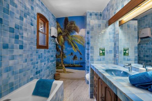 a blue tiled bathroom with a tub and a sink at Chambres D'hôtes - Le Mas Du Rocher in Hyères