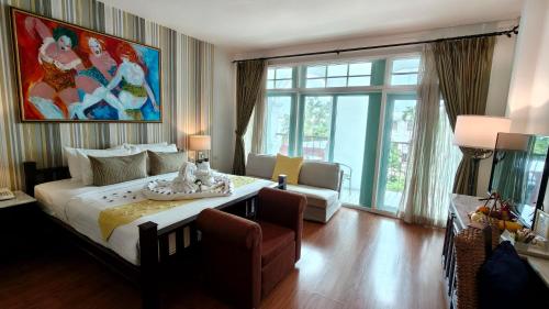 a bedroom with a large bed with a table and a couch at Casa Blanca Boutique Hotel - SHA Plus in Phuket