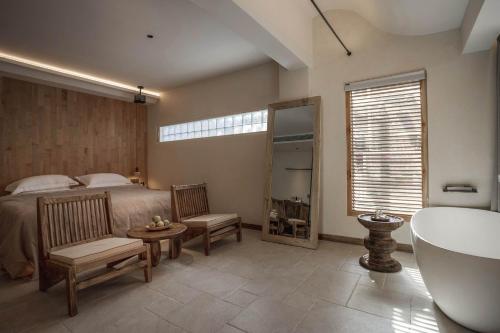 a bedroom with a bed and a tub and a sink at Dali Jiwu Hotel in Dali